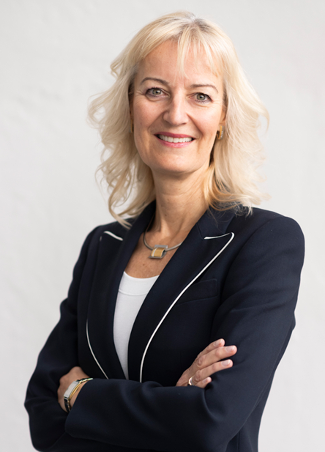 A person with blonde hair wearing a black jacket
Description automatically generated